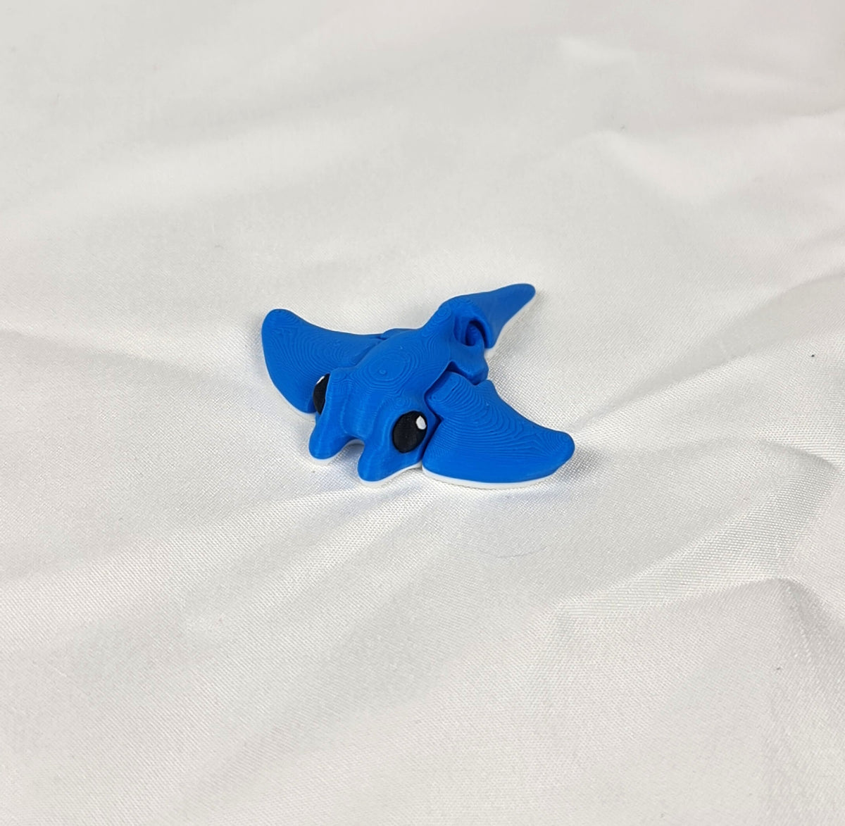 Blauwe 3D-geprinte mini manta rog vanuit een schuine hoek gefotografeerd als origineel cadeau