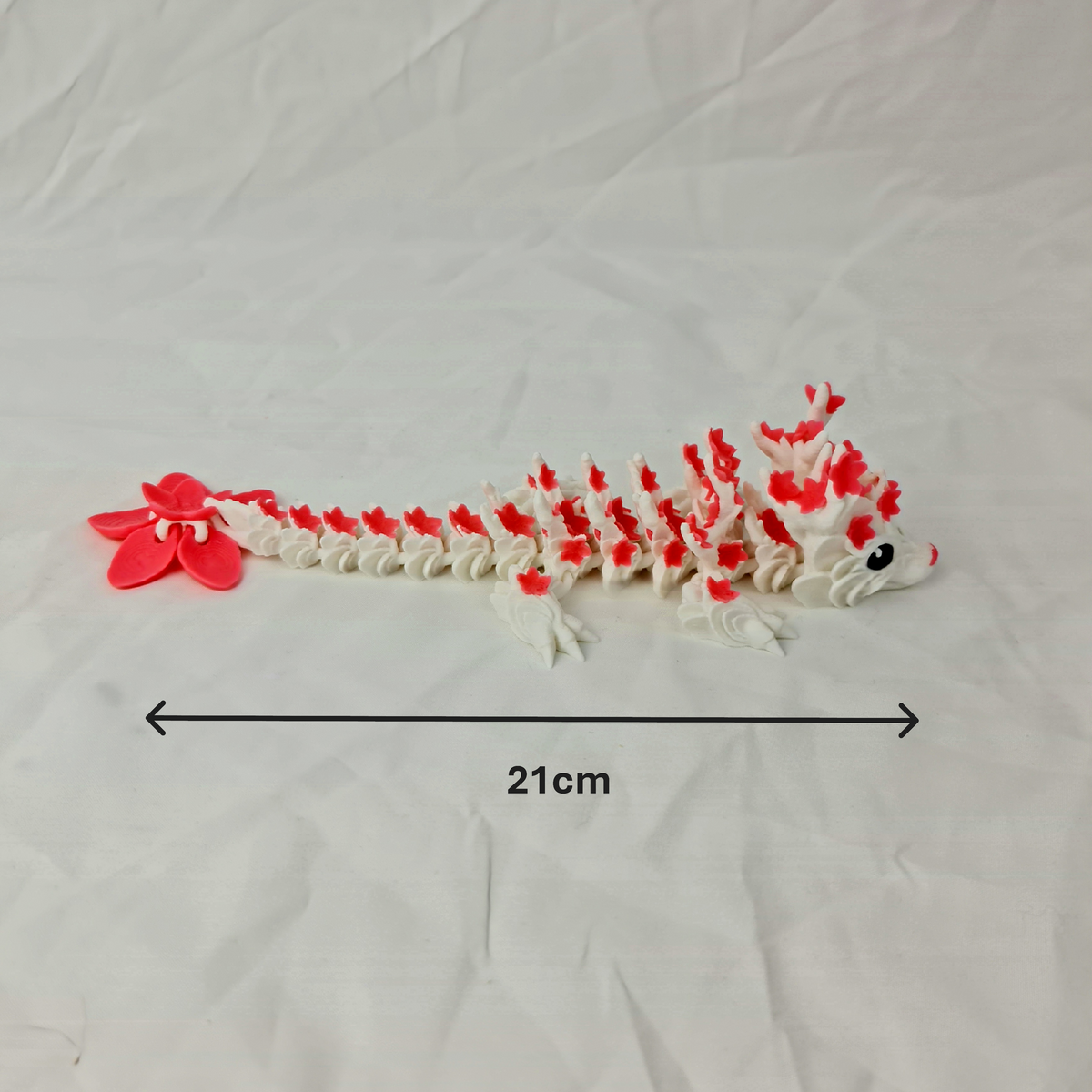 Zijaanzicht van de gearticuleerde cherryblossom baby draak met maataanduiding van de lengte in centimeters.