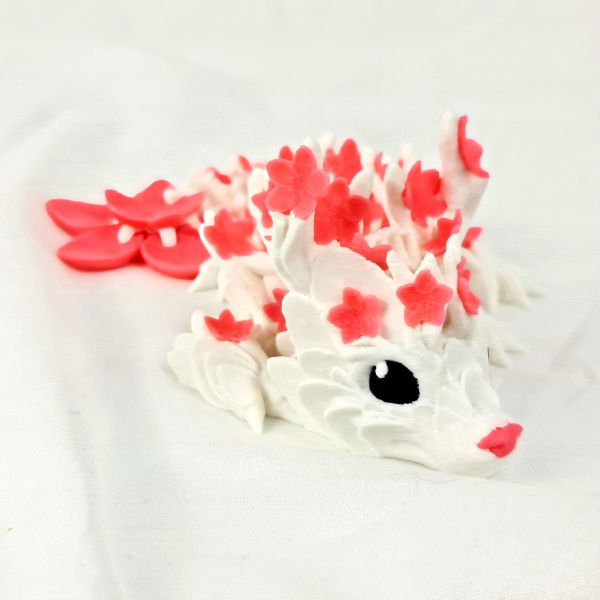 Vooraanzicht van de gelede cherryblossom baby draak van PLA-kunststof op een witte achtergrond.