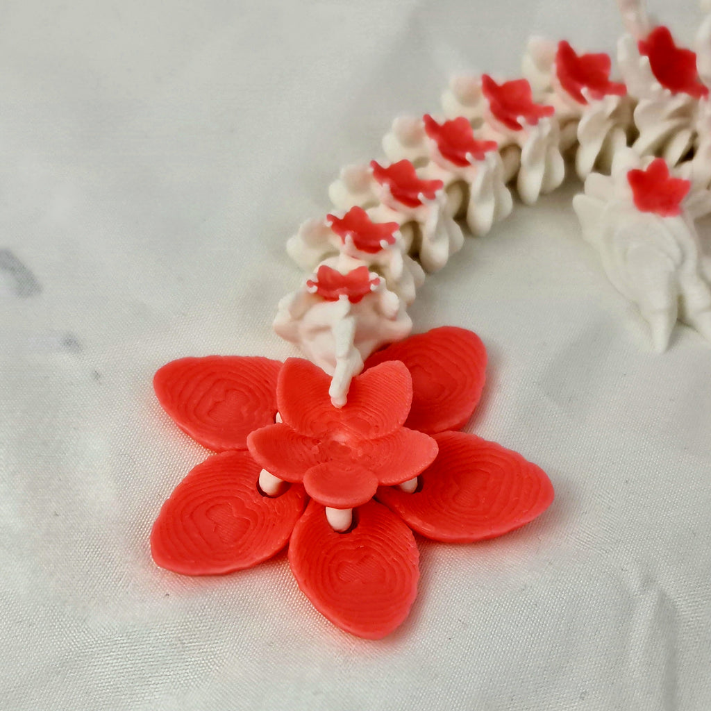 Detailfoto van de staart van de 3D-geprinte draak en de losse roze kersenbloesem.