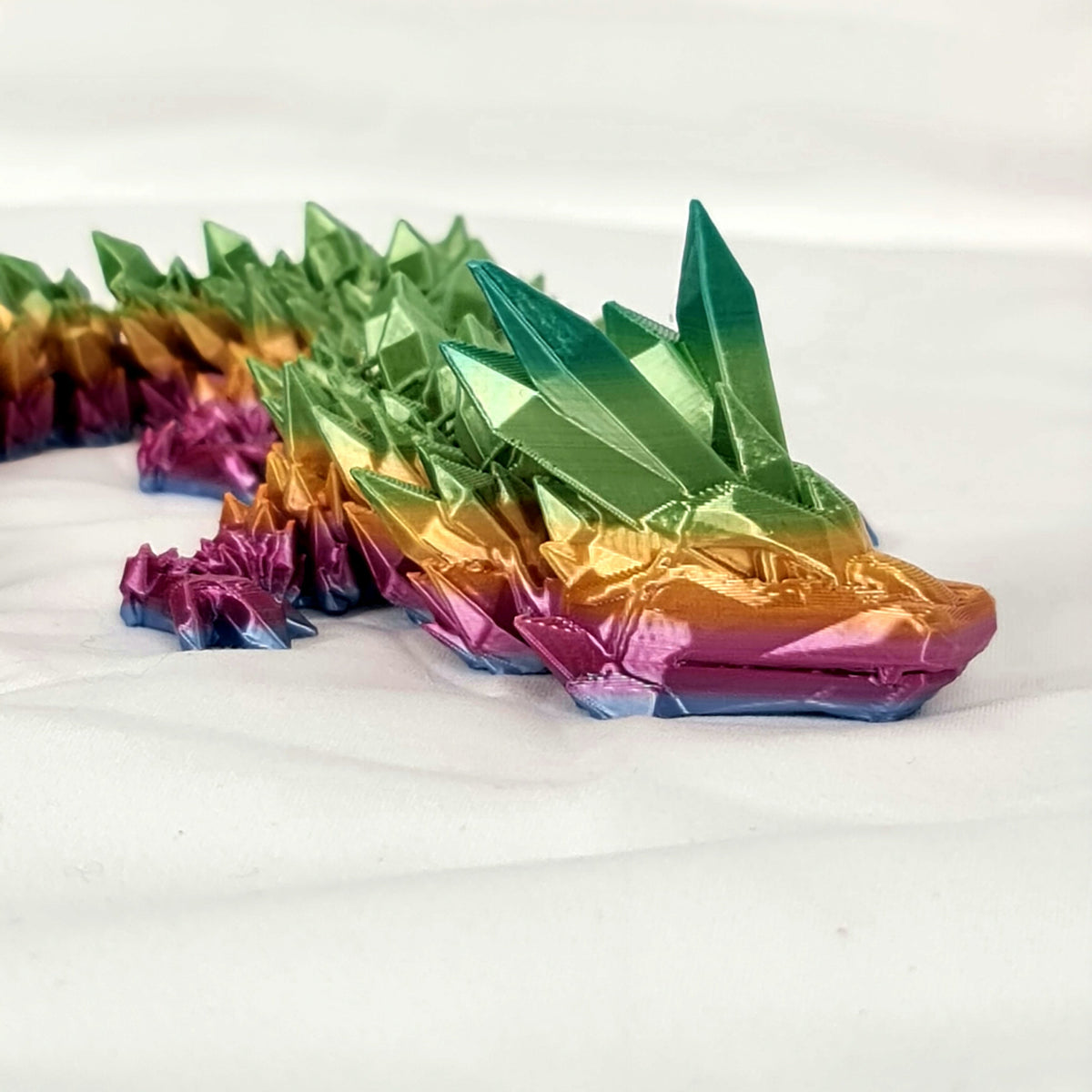 Close-up van de kop en kristalgedeelten van de meerkleurige 3D-geprinte kristaldraak.
