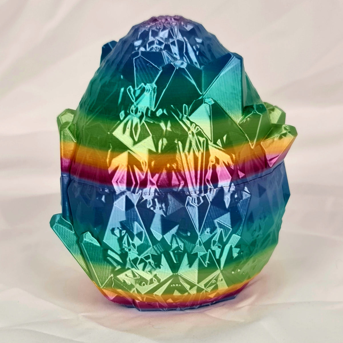 Gesloten 3D-geprint kristal-draakenei met glanzend regenboogverloop.