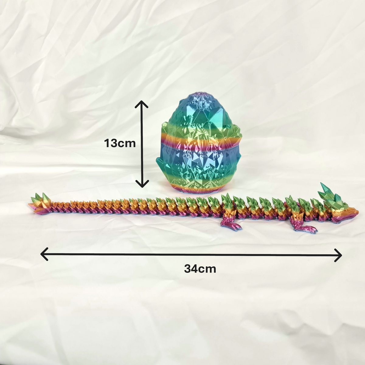 Zijaanzicht van de gelede regenboog kristaldraak en ei met maataanduidingen in centimeters.