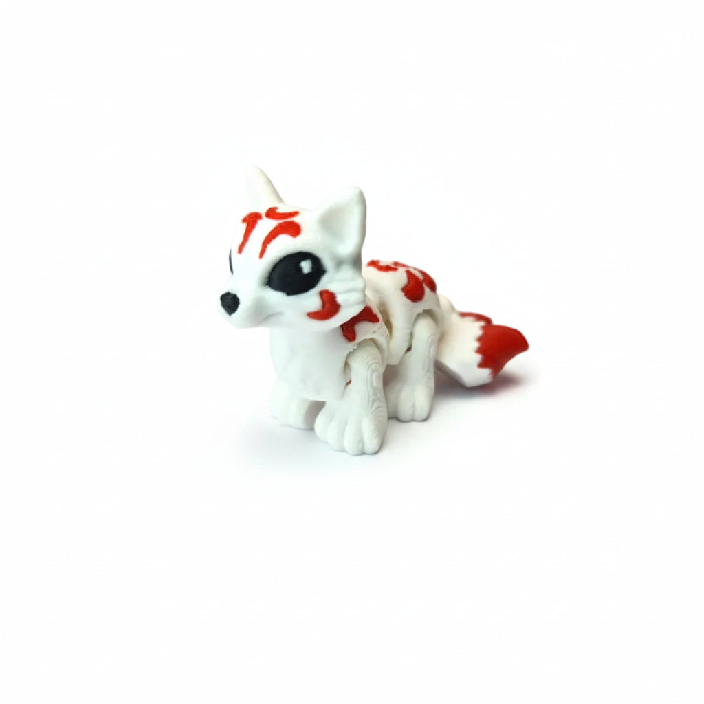 Handgemaakte 3D-geprinte flexibele mini Kitsune vos in wit met rode markeringen op een witte achtergrond, als uniek verzamelobject