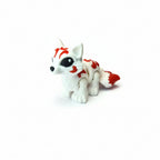 Handgemaakte 3D-geprinte flexibele mini Kitsune vos in wit met rode markeringen op een witte achtergrond, als uniek verzamelobject