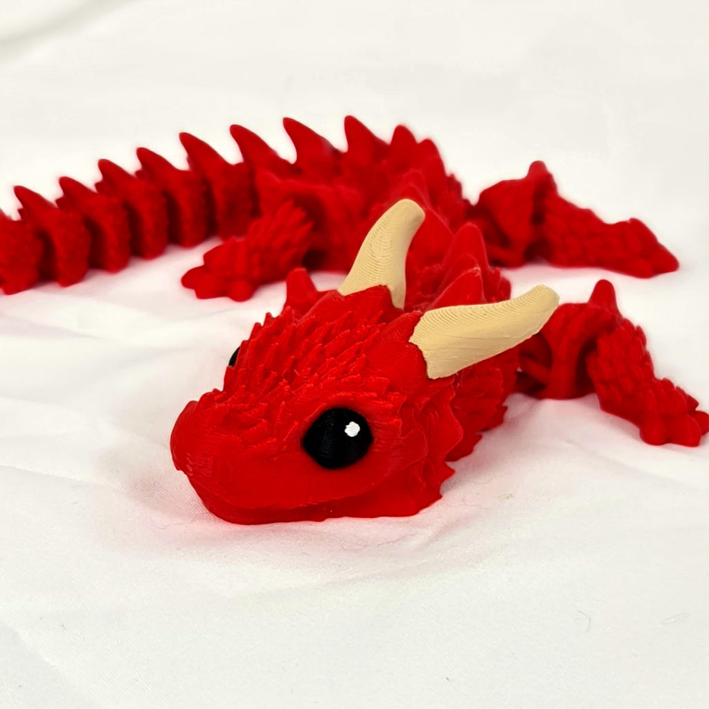Close-up van het schattige gezicht van de rode 3D-geprinte Ragnar draak op een witte achtergrond.