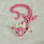 Vooraanzicht van de liggende roze baby draak met witte hoorntjes op een neutrale ondergrond.