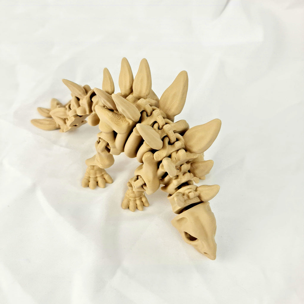 Hoge hoek opname van de beige 3D-geprinte skelet stegosaurus rustend op een witte achtergrond.
