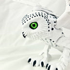 Zijaanzicht van de 3D-geprinte sneeuwuil met geaccentueerde zwarte vlekjes op de vleugels