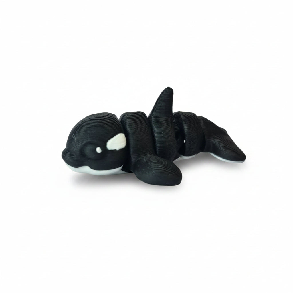 Handgemaakte 3D-geprinte flexibele mini orca walvis in zwart-wit op een witte achtergrond, als uniek verzamelobject