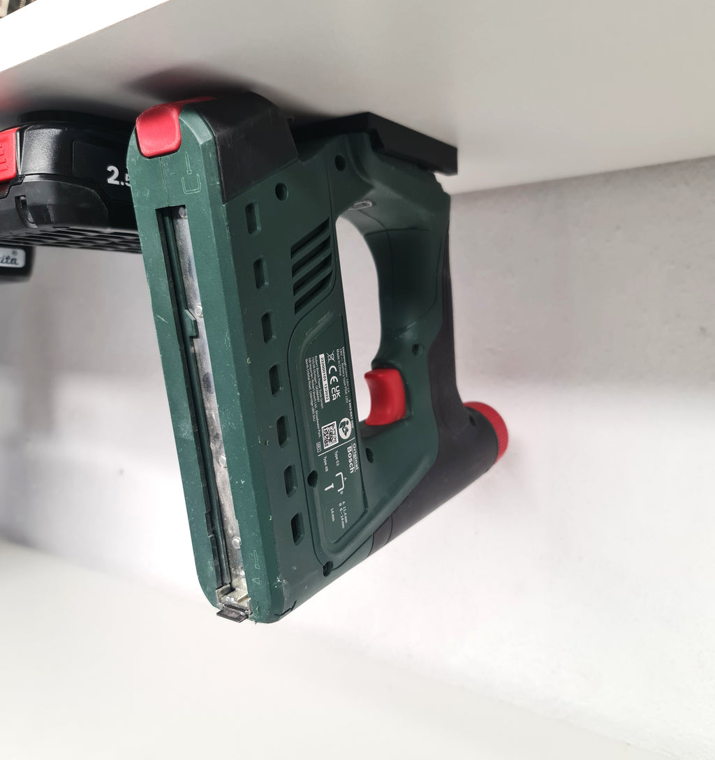 Bosch PBA accu gereedschap ondersteboven opgehangen onder een stellingkast met zwarte wandhouder