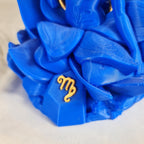 Close-up van het gouden astrologische Maagd symbool op de sokkel van het handgemaakte 3D-geprinte beeld
