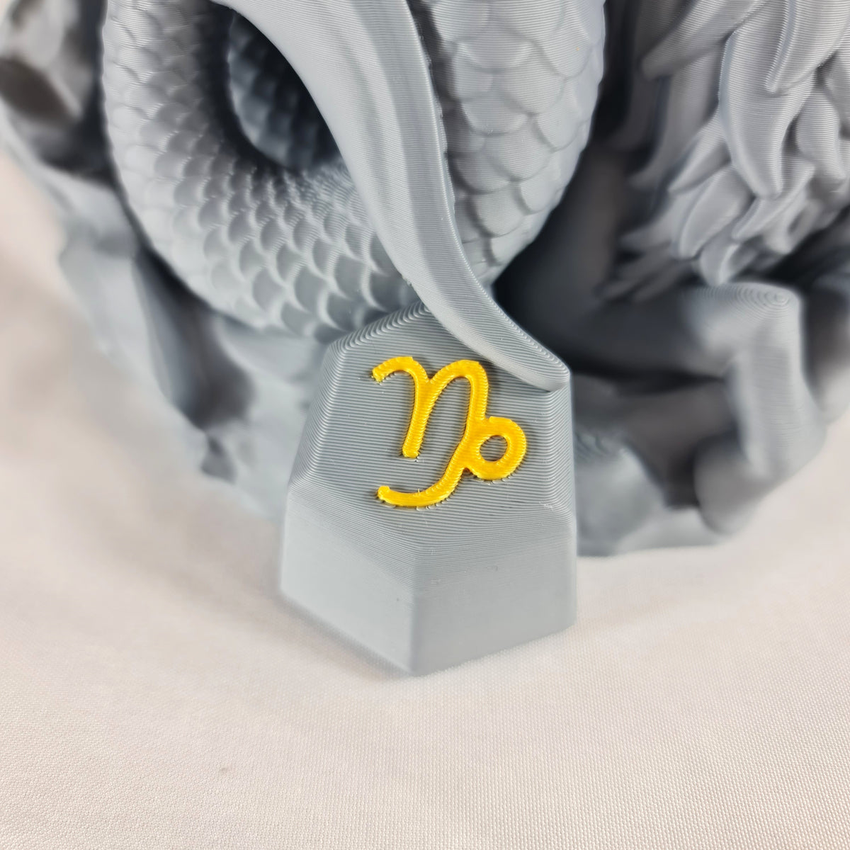 Close-up van het gouden astrologische Steenbok symbool op de sokkel van het handgemaakte 3D-geprinte beeld