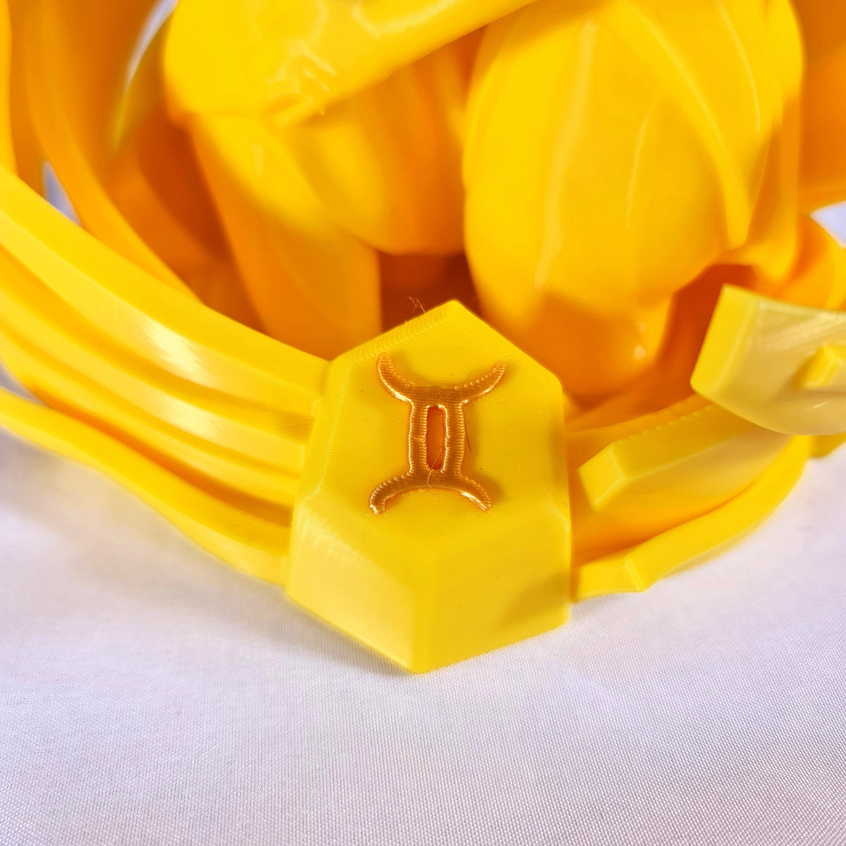 Close-up van het gouden astrologische Tweeling symbool op de sokkel van het handgemaakte 3D-geprinte beeld