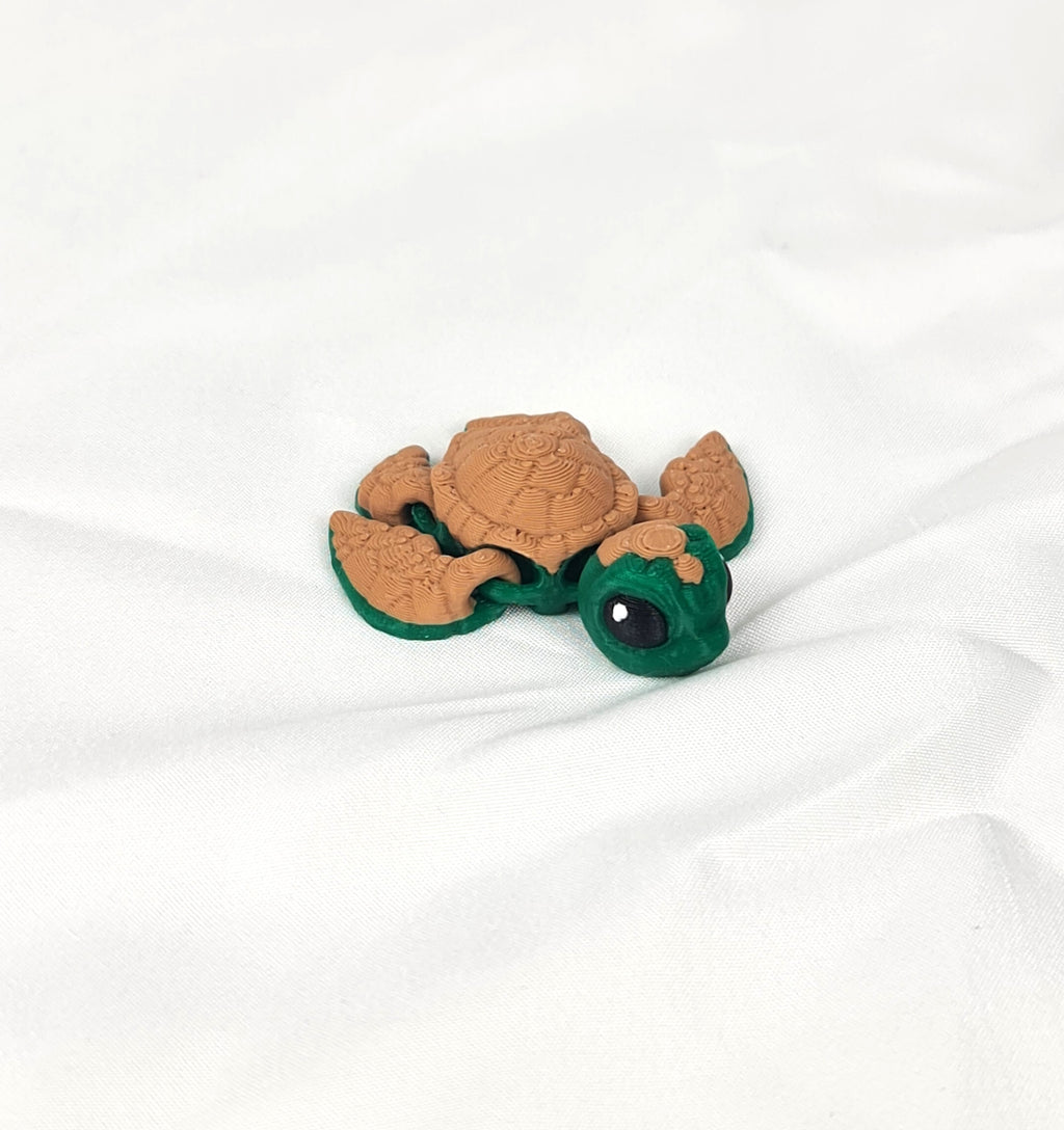 Close-up detailfoto van de flexibele gewrichten van de bruin-groene 3D-geprinte schildpad op een wit textieloppervlak.