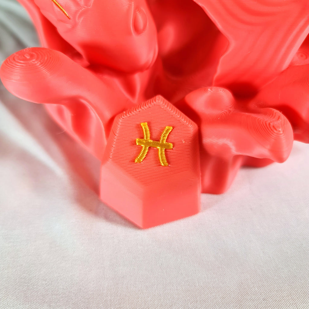 Close-up van het gouden astrologische Vissen symbool op de sokkel van het handgemaakte 3D-geprinte beeld