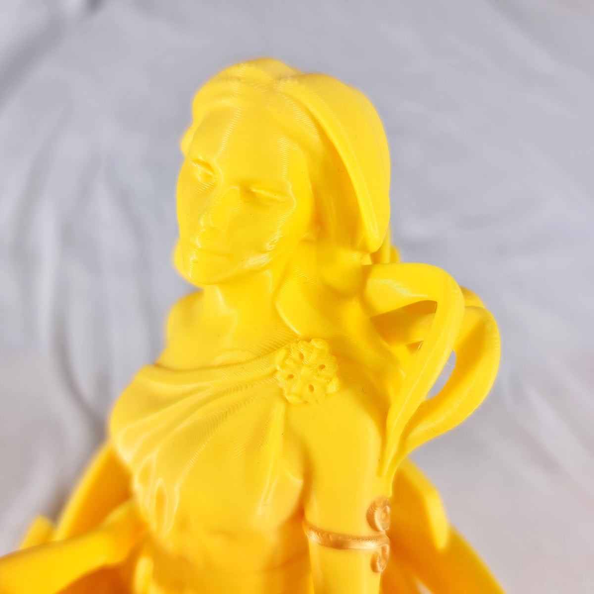 Detailopname van de gedetailleerde gezichten en gouden kledingaccenten van het gele 3D-geprinte Tweeling sterrenbeeld beeld