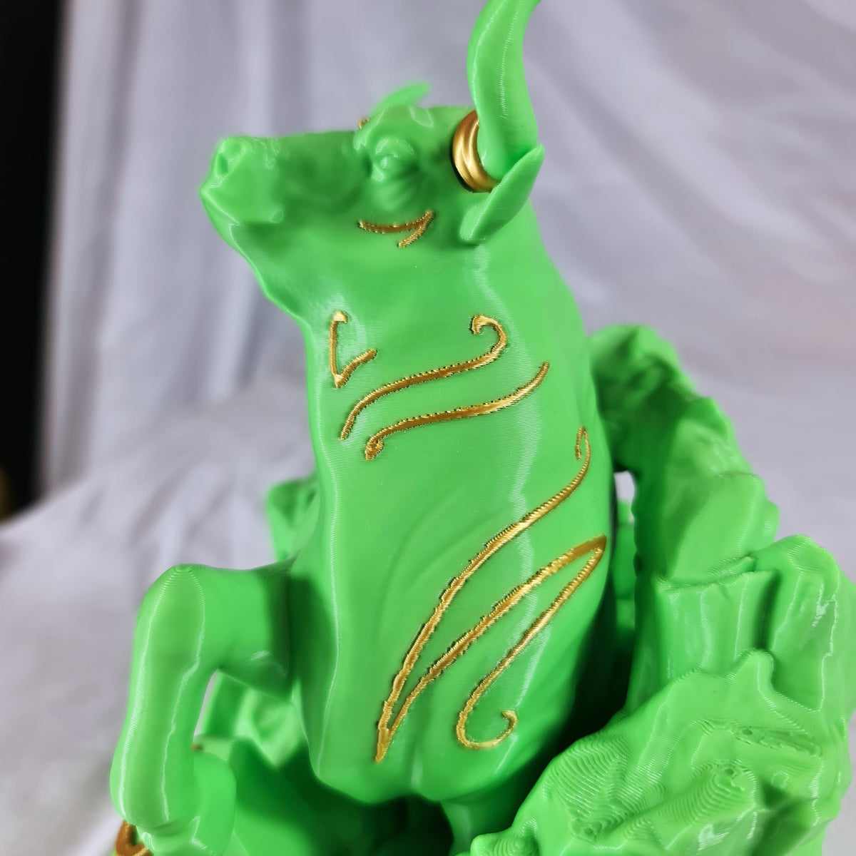 Detailopname van de fijne gouden accenten op de kop en hoorns van het groene 3D-geprinte Stier sterrenbeeld beeld