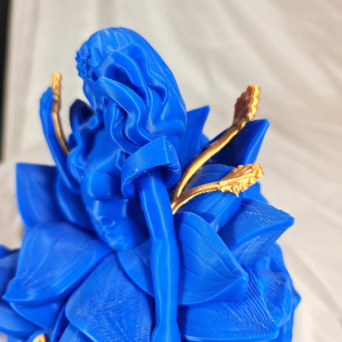 Detailopname van de fijne gouden tarwe-elementen die door het blauwe 3D-geprinte Maagd sterrenbeeld beeld worden vastgehouden
