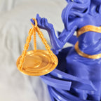 Close-up van de gedetailleerde gouden weegschaal die wordt vastgehouden door het 3D-geprinte Weegschaal sterrenbeeld beeld