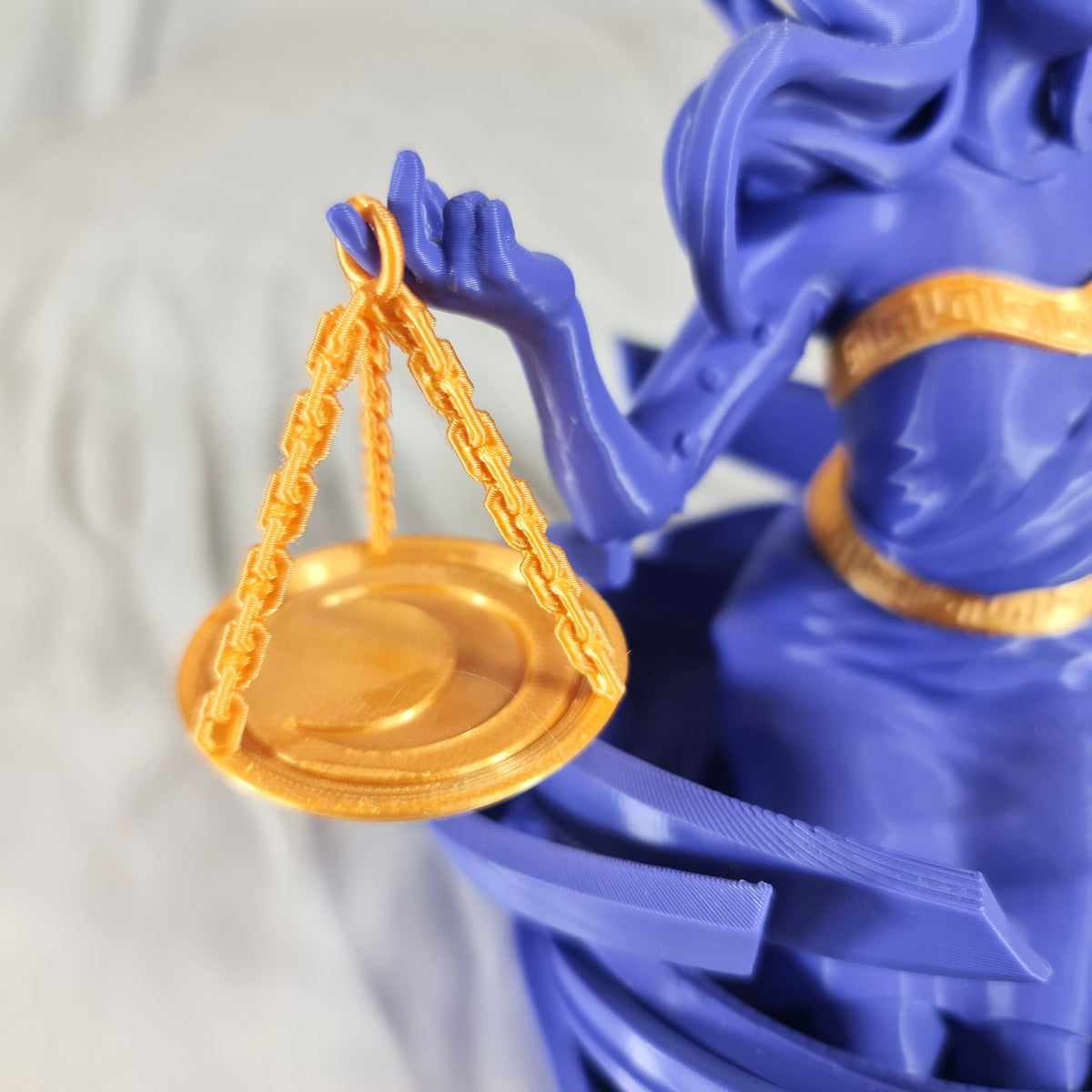 Close-up van de gedetailleerde gouden weegschaal die wordt vastgehouden door het 3D-geprinte Weegschaal sterrenbeeld beeld