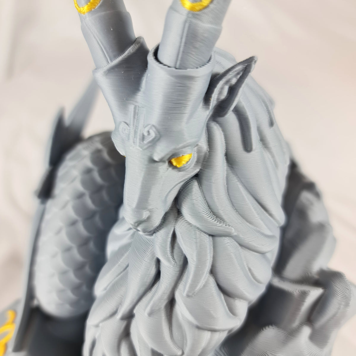 Close-up opname van de gedetailleerde kop, ogen en hoorns met gouden markeringen van het 3D-geprinte Steenbok sterrenbeeld
