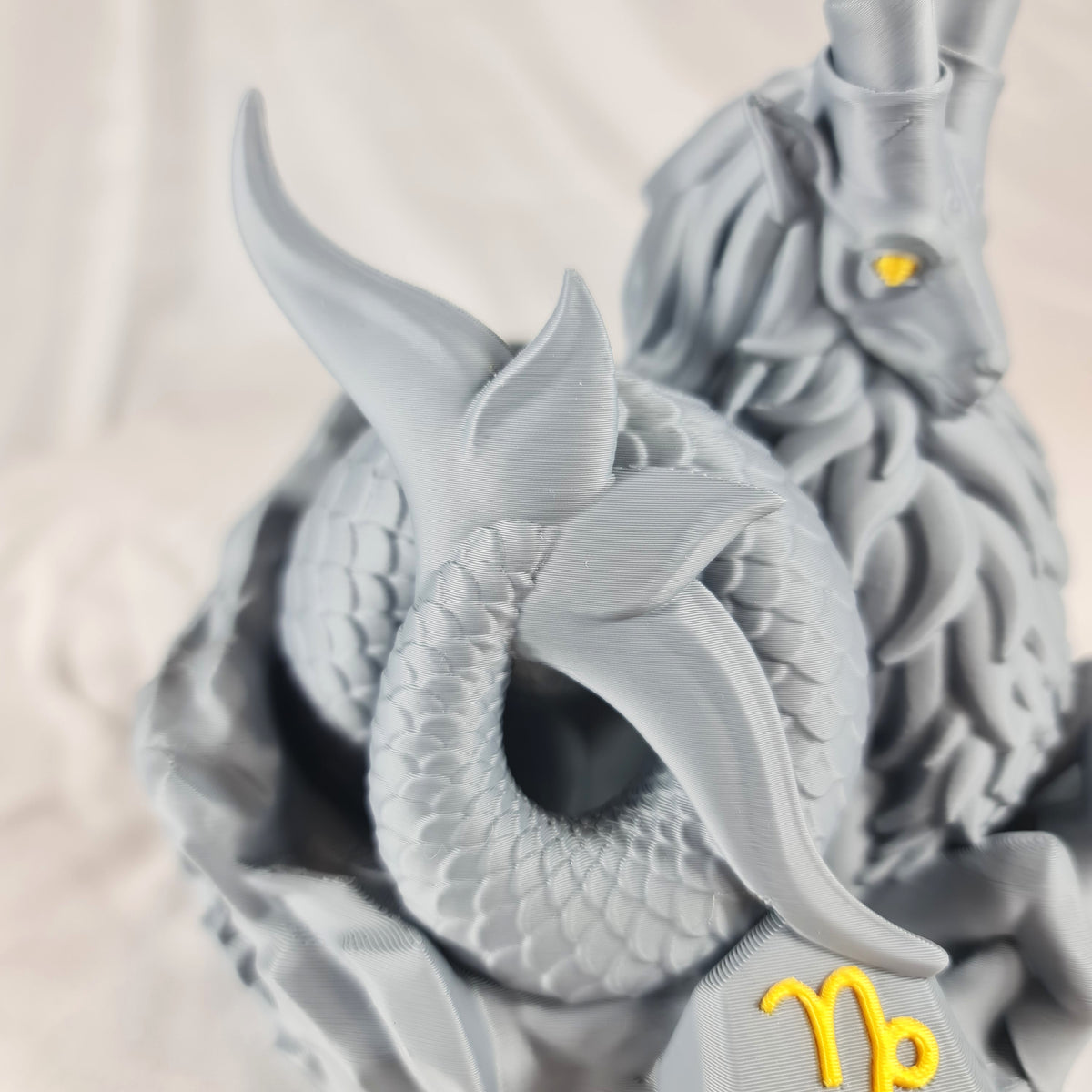 Detailopname van de karakteristieke visstaart en de gedetailleerde textuur van het grijze 3D-geprinte Steenbok sterrenbeeld beeld