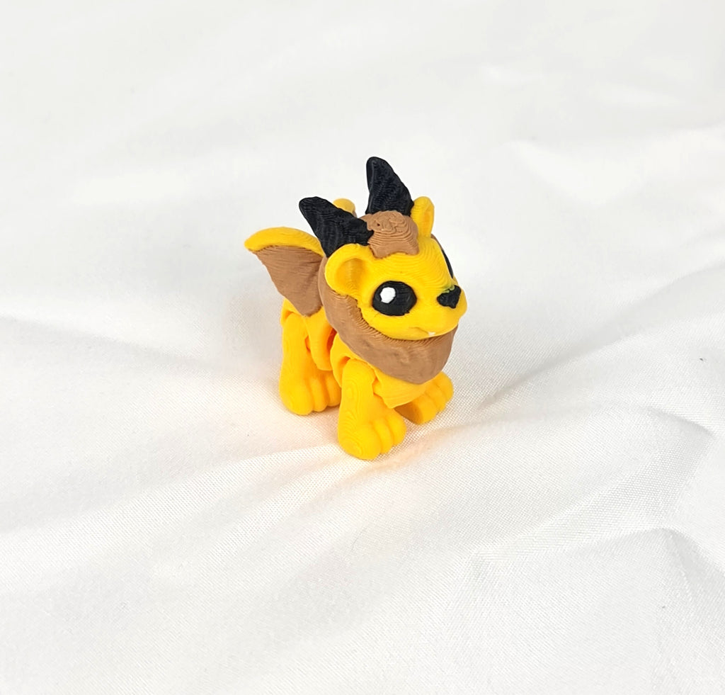 De gele en bruine 3D-geprinte flexibele mini manticore gefotografeerd vanuit een schuine hoek als decoratief kunstobject