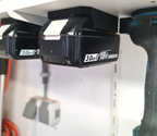 Praktische wandhouder voor Makita LXT 18V accu's netjes gemonteerd onder een legplank in een opgeruimde schuur