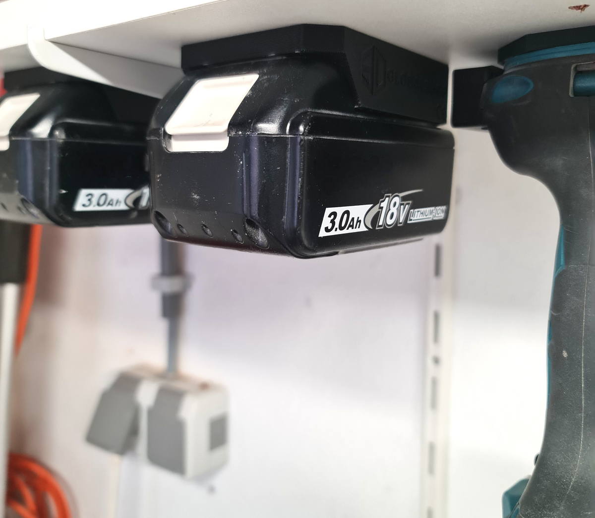 Praktische wandhouder voor Makita LXT 18V accu's netjes gemonteerd onder een legplank in een opgeruimde schuur