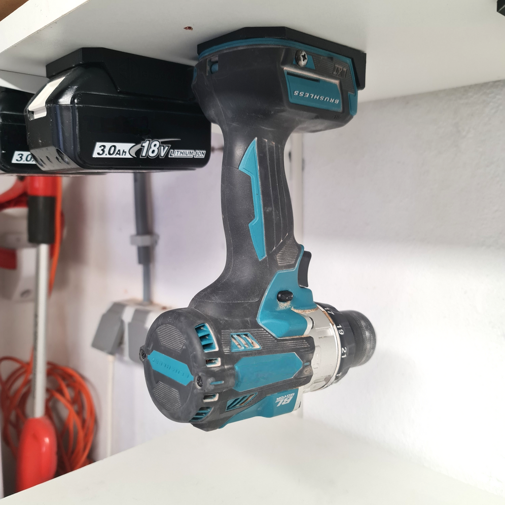 Praktische wandhouder voor Makita LXT 18V gereedschap gemonteerd onder een plank in een opgeruimde werkplaats of schuur