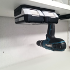 Praktische wandhouders voor Makita G-Series 18V accu's en gereedschap netjes gemonteerd onder een legplank in een opgeruimde werkplaats
