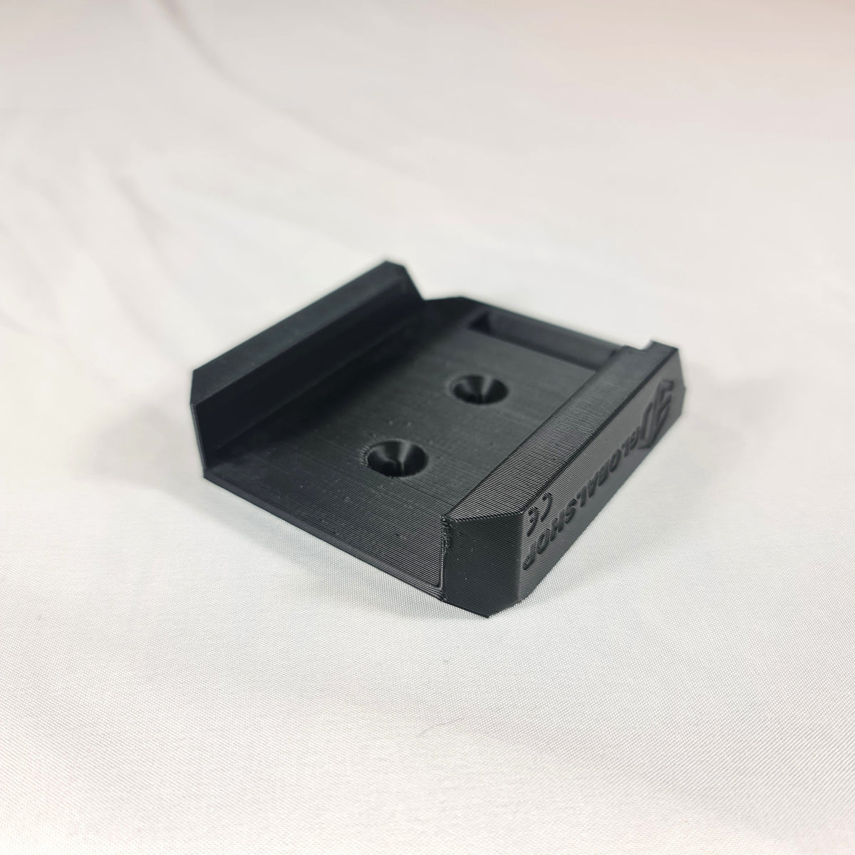 Schuine hoekweergave van de 3D-geprinte Makita LXT 18V accuhouder met duidelijke tekstmarkering en stevige behuizing