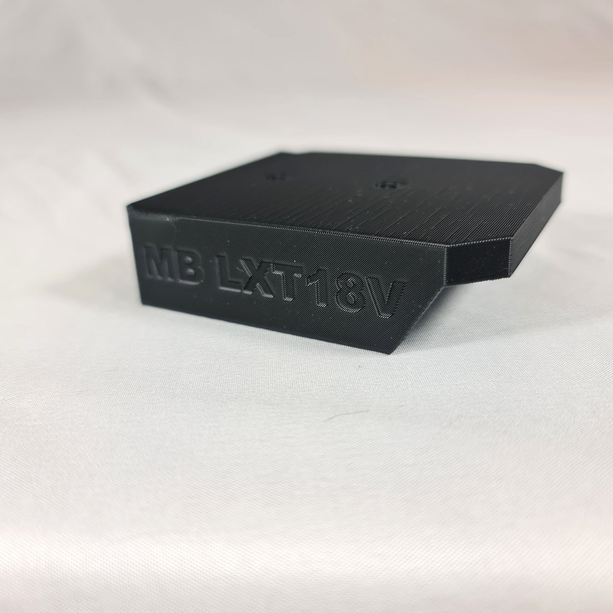 Detailopname van de voorgevormde schroefgaten in de 3D-geprinte Makita LXT 18V accuhouder voor eenvoudige wandmontage