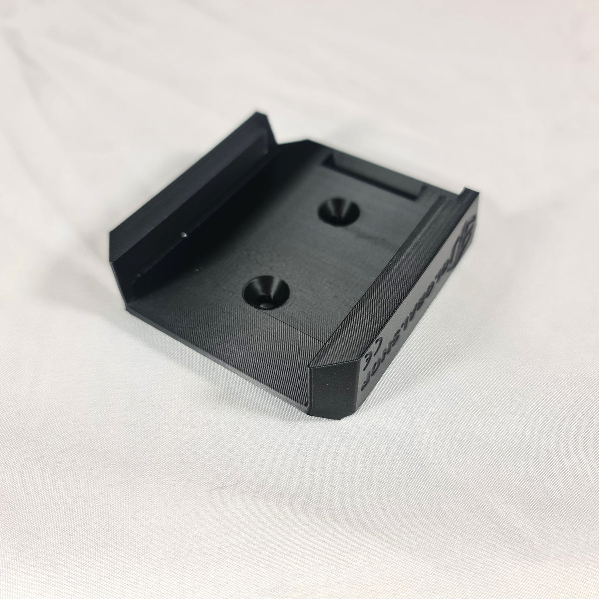 Detailopname van de voorgevormde schroefgaten in de 3D-geprinte Makita G-Series 18V accuhouder voor eenvoudige wandmontage