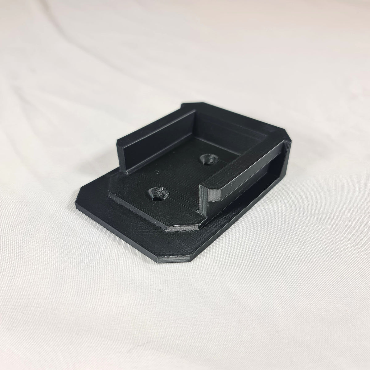Schuine hoekweergave van de 3D-geprinte Makita G-Series 18V gereedschapshouder inclusief de voorgevormde schroefgaten