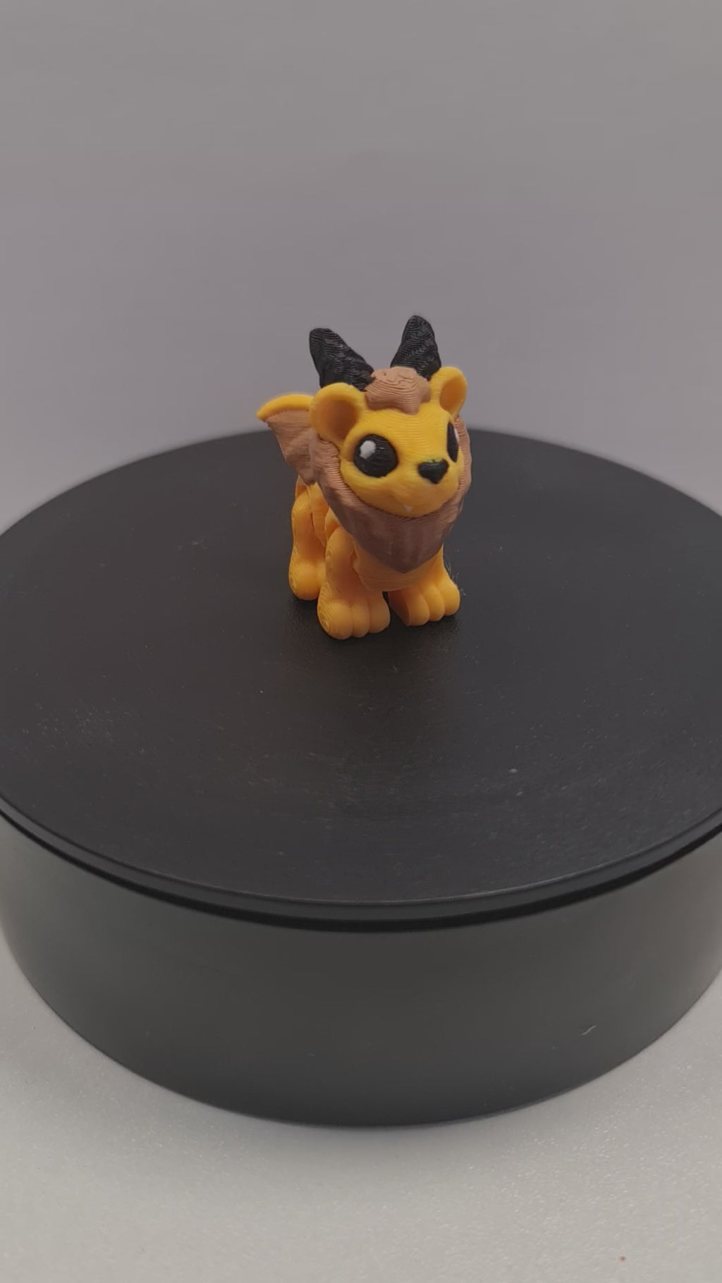 Video still van de flexibele 3D-geprinte mini manticore die ronddraait op een zwarte draaitafel om de beweegbare gewrichten te tonen