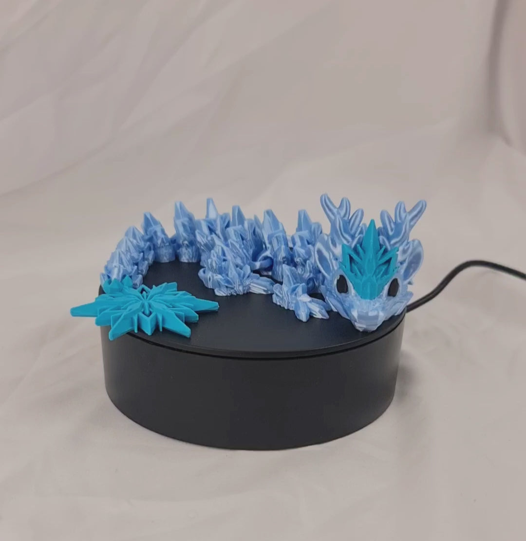 Video van de flexibele 3D-geprinte winter baby draak op een draaiend displayplatform.