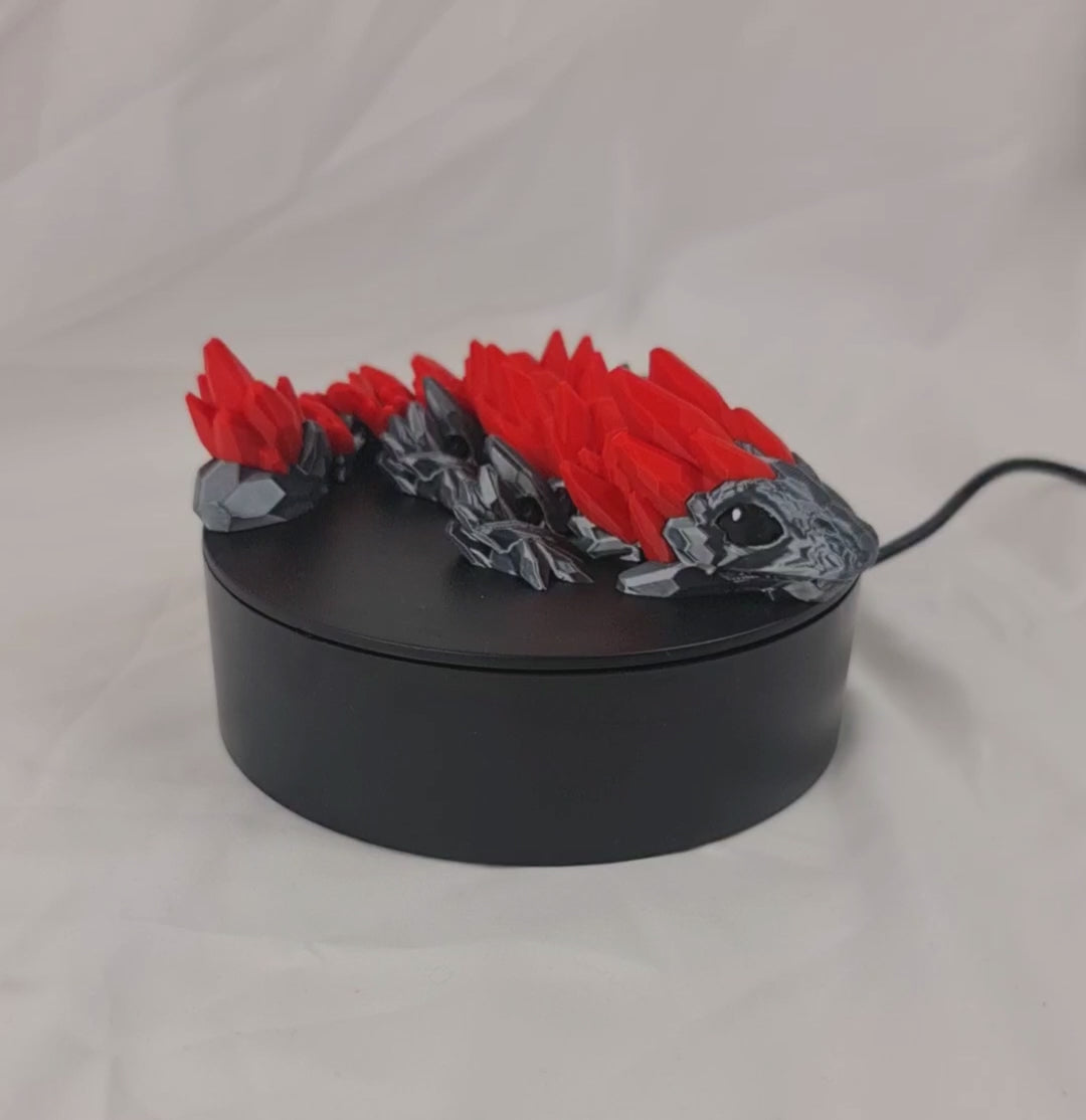Video van de buigzame 3D-geprinte gemstone baby draak op een draaiend displayplatform.