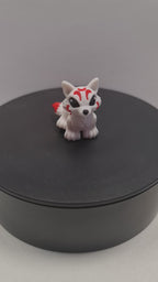 video still van de flexibele 3D-geprinte mini Kitsune die ronddraait op een zwarte draaitafel om de beweegbare gewrichten te tonen