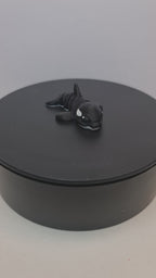 Video still van de flexibele 3D-geprinte mini orca die ronddraait op een zwarte draaitafel om de beweegbare gewrichten te tonen