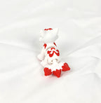 De witte en rode 3D-geprinte flexibele mini Kitsune gefotografeerd vanuit een hoek met zicht op de staart als decoratief kunstobject